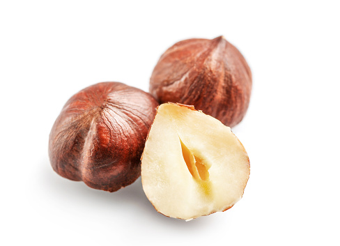 Whole and halved hazelnuts isolated on white background. Copy space.