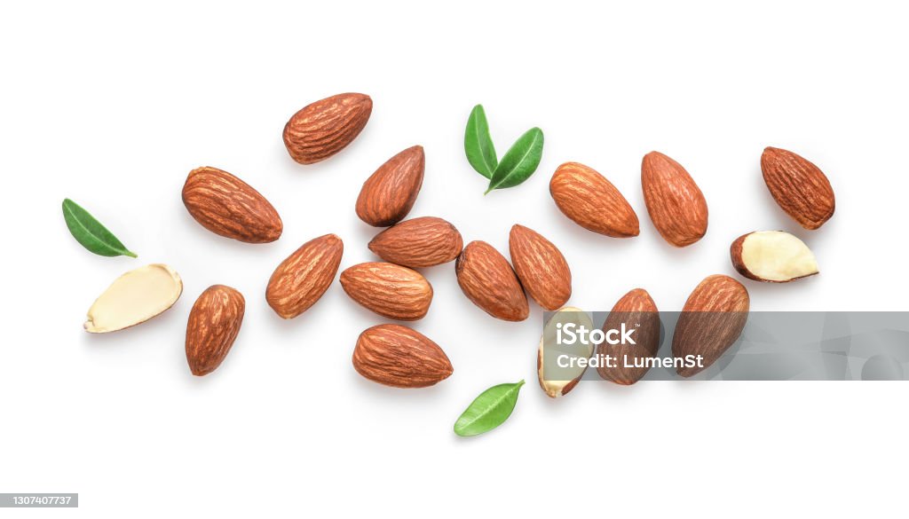 Tasty and nutritious almond nuts Whole and halved almond nuts with leaves isolated on white background. Top view. Almond Stock Photo