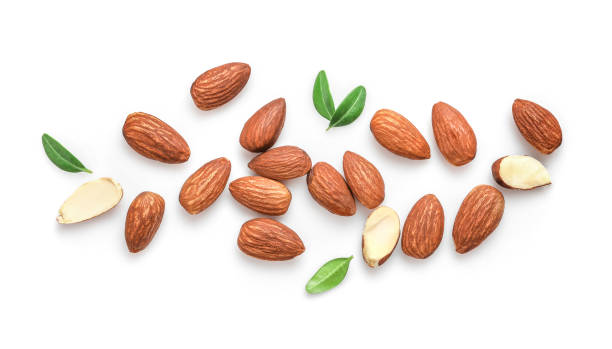 Tasty and nutritious almond nuts Whole and halved almond nuts with leaves isolated on white background. Top view. almond stock pictures, royalty-free photos & images