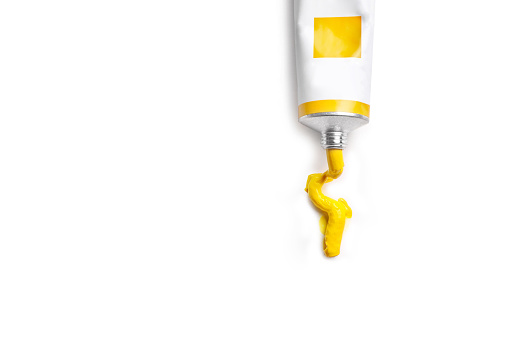 Tube with yellow paint isolated on white background. Copy space.