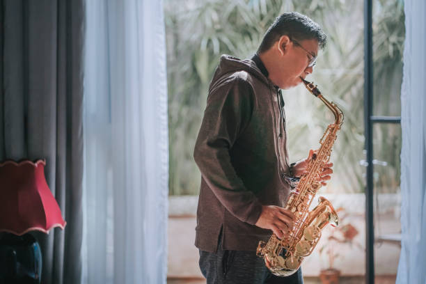 istock lifehack asian chinese mature man practicing saxophone at home during weekend leisure time 1307408119