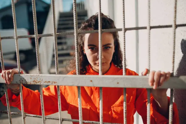 Young brunette curly woman in orange suit. Female in colorful overalls portrait