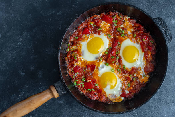 istock Shakshuka, fried eggs with tomatoes, onion, red pepper and spices in cast iron pan 1307409963