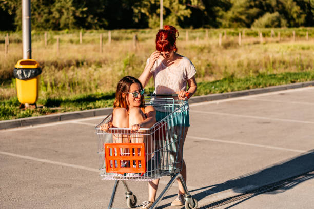 istock Two women  riding shopping cart 1307410019