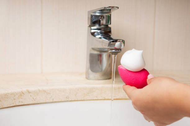 istock Woman cleansing makeup sponge with foam over sink 1307410830