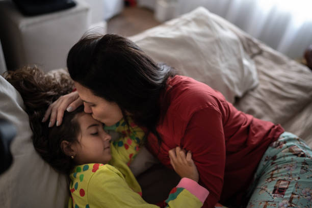 istock Mother and daughter lying in bed 1307410978