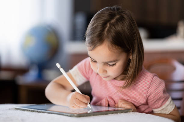 istock Little Child Girl Drawing On Digital Tablet Using Digitized Pen 1307411497