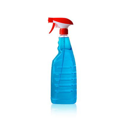 Transparent, large spray bottle with blue soapy liquid for cleaning glass and windows, isolated against a white background. with clippng path