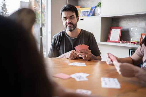 Focused man playing cards with family at home