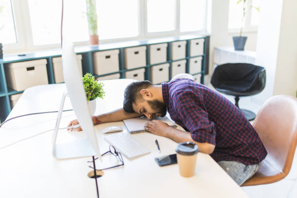 istock Indian Businessman sleeping over working place in office 1307414857