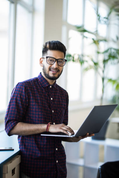 istock Confident young businessman working on laptop in the office 1307415701