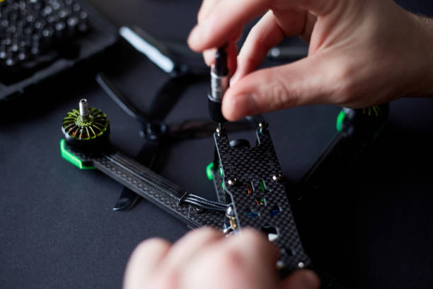 istock Close up of man's hands assembling a FPV drone from parts, using tools, Preparing high-speed racing quadcopter for flight. Repair drone before training process. 1307416889