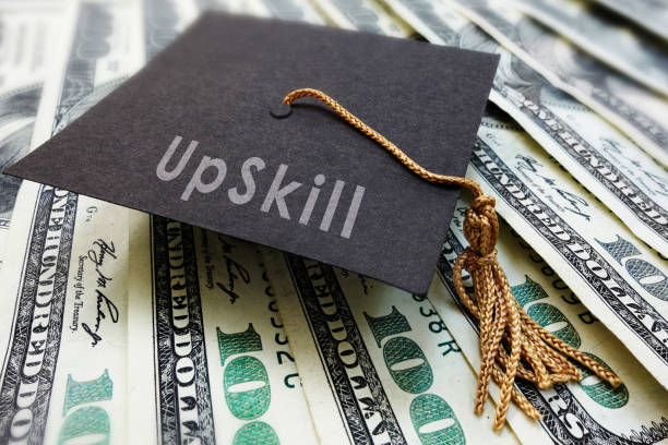 istock Mini graduation cap with Upskill text on money 1307416931