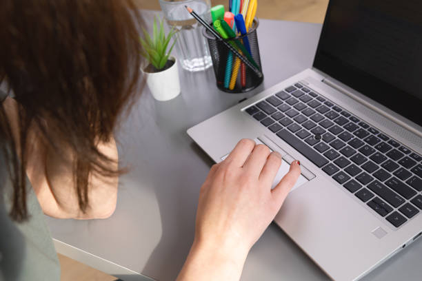 istock Top view of women browsing in internet by using a mouse pad. Working from home a new normal working concept. 1307416993