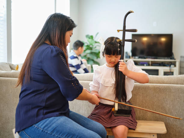 young chinese family in their home - erhu imagens e fotografias de stock