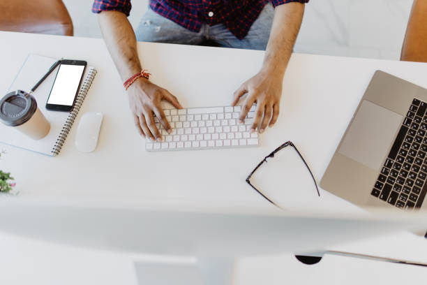 istock Above view of man hands working on keyboard in modern office desk 1307419419