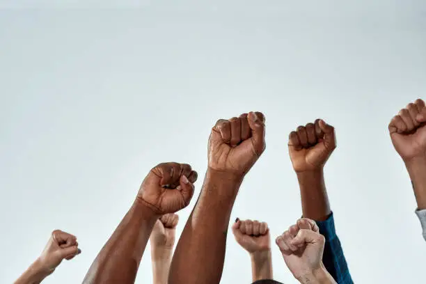 Photo of Raised hands of multiracial people clenched into fists