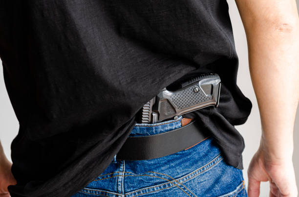 istock Gun. Hided handgun under the denim belt. 1307422863