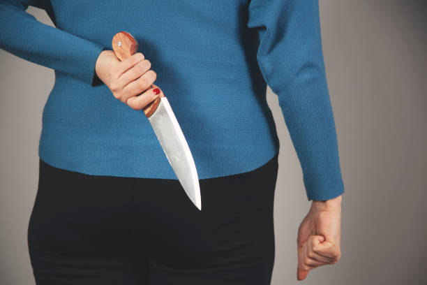 istock woman hand holding knife in back 1307422898