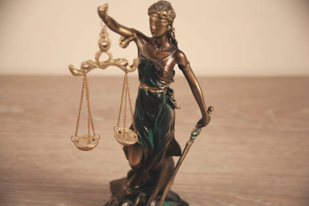 istock justice lady on the desk on yellow background 1307422914