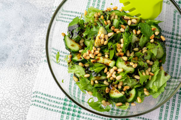 istock Healthy food concept: green salad with cucumbers, mint, pine nuts and balsamic. Selective focus. Organic food concept. 1307424407