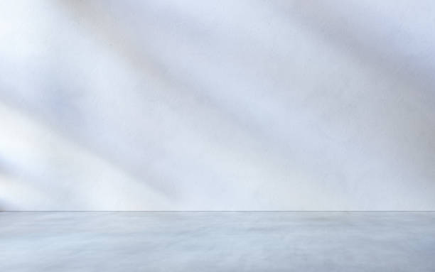 istock White textured wall and grey concrete floor as place for displaying your product. 1307424976