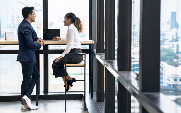 istock Colleagues talk while standing at the office window, Communication with colleagues, Business people. 1307425562