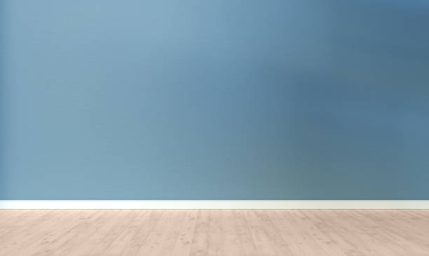 istock Light blue textured wall and wooden floor in empty room for displaying your product, light coming through window. 1307425621