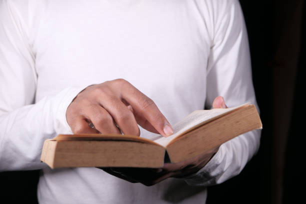 istock hand holding a book on black background 1307427494
