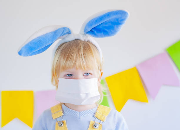 istock child boy in a protective mask and with easter bunny ears 1307427560