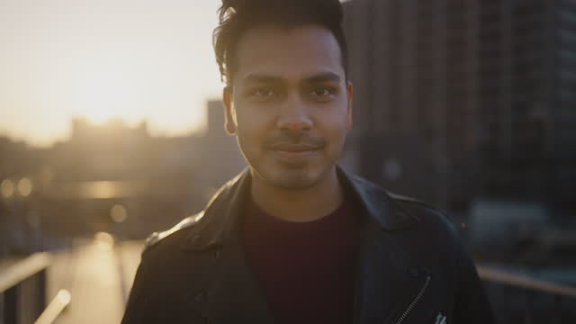 Portrait of young and handsome Indian man in city during sunset