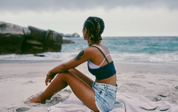 Shot of a young woman spending the day at the beach