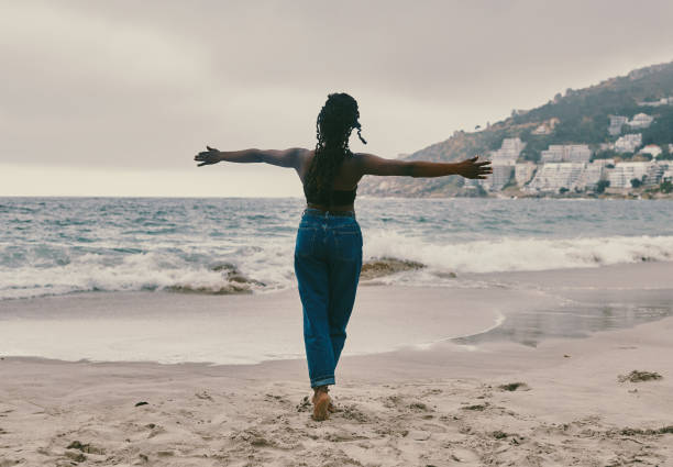 Rearview shot of a young woman spending the day at the beach