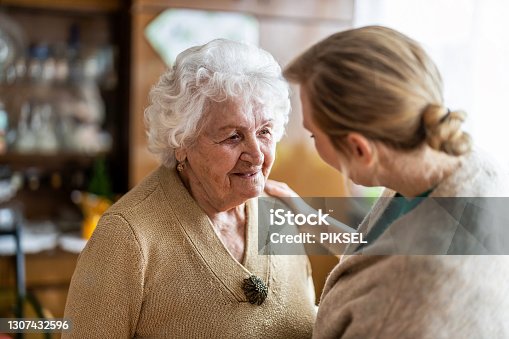 istock Health visitor talking to a senior woman during home visit 1307432596