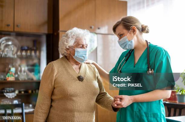 Senior Woman Visited By Home Care Specialist During Lockdown Stock Photo - Download Image Now