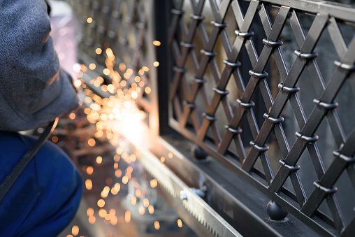 Welding the steel gear racks to gate. Last phase before setting up an automated gate operator. Professional service of installation and maintenance of automatic cantilever sliding gate.