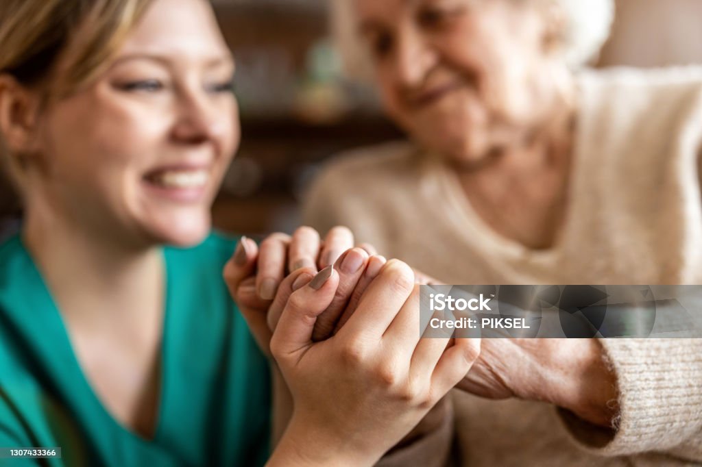 Cropped shot of a senior woman holding hands with a nurse Care Stock Photo