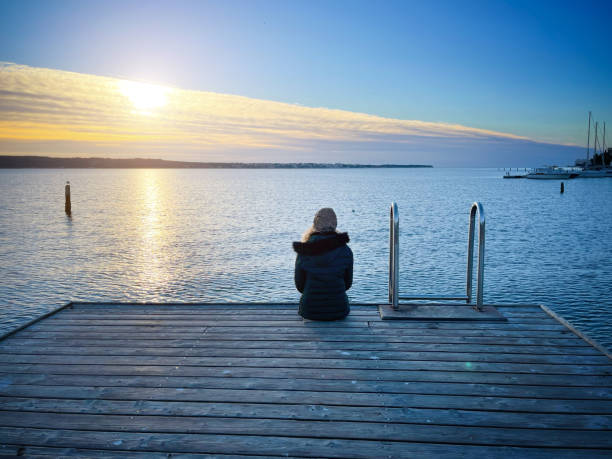 istock Lonely woman enjoying watching sunset at seaside 1307433756