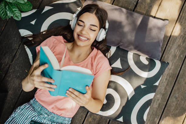 istock Young woman reading a book on the terrace 1307434865