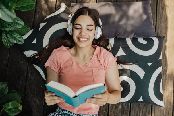 istock Young woman reading a book on the terrace 1307434918