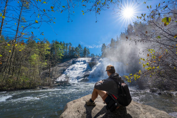 ハイキング旅行で滝のそばでリラックスした男。 - dupont state forest ストックフォトと画像