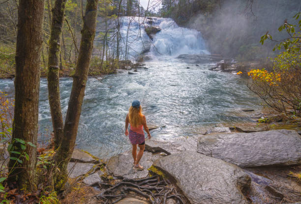 Woman relaxing by beautiful waterfall.