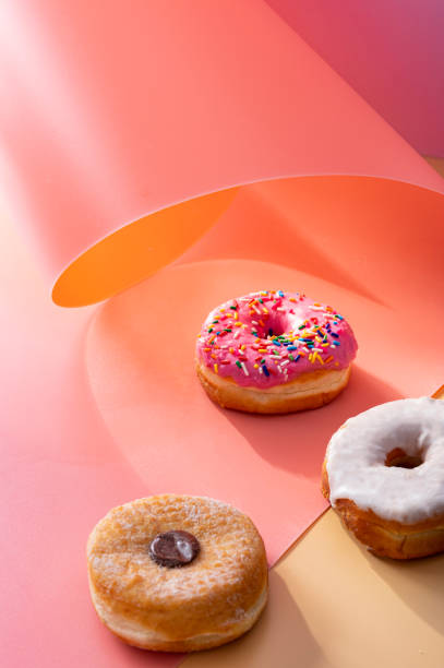 istock Mix of donuts on pink and caramel swirled background with copy space 1307436236