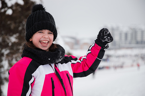 Happy young girl preparing for skiing outdoors