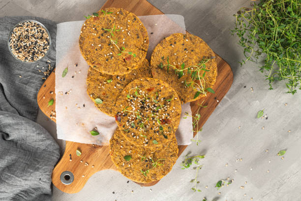 istock Raw veggie burger with lentils, vegetables and thyme leaves on kitchen countertop. Top view. Flat lay 1307436899
