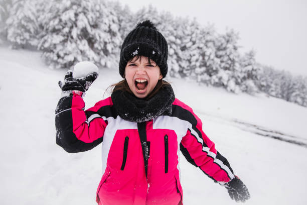 Happy kid having snowball fight outdoors
