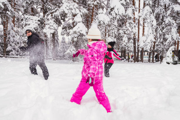 istock Girl throwing snowballs on her dad 1307436970