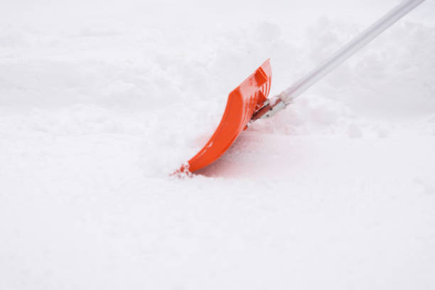 Orange shovel stuck in the snow