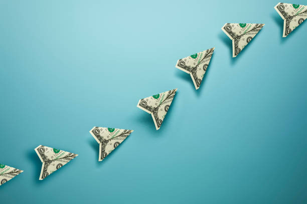 istock US Dollar Bill Paper Airplanes with Dotted Chalk Path Creative Idea on Blue Background 1307438392