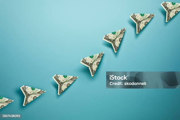 Us Dollar Bill Paper Airplanes With Dotted Chalk Path Creative Idea On Blue Background Stock Photo - Download Image Now